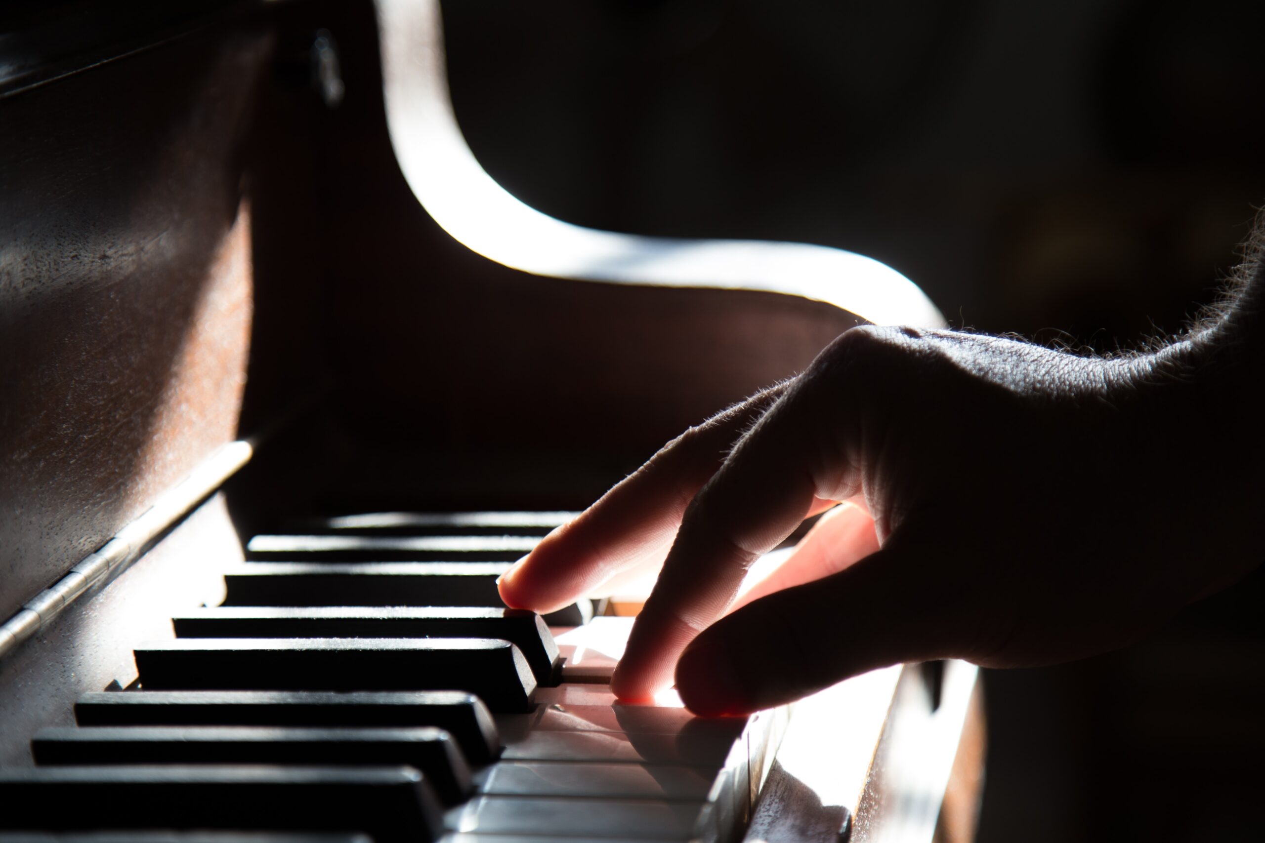 tadas-mikuckis-Close up of Right hand on piano keys-unsplash