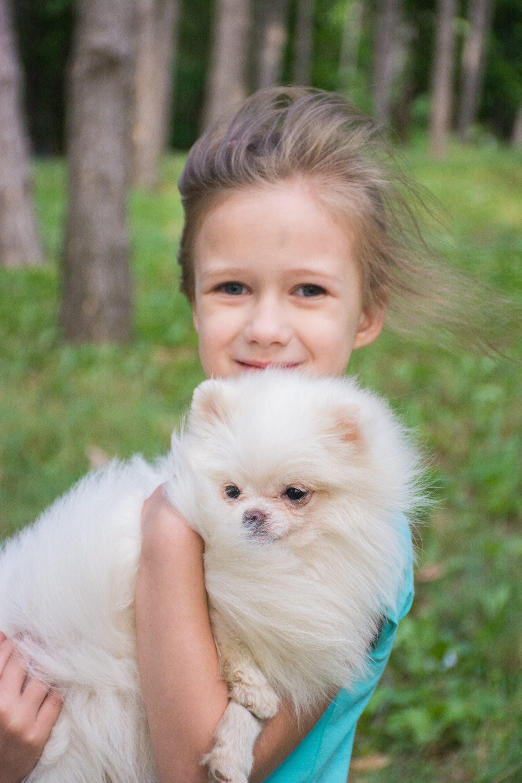 Girl holding pomeranian dog in the wind