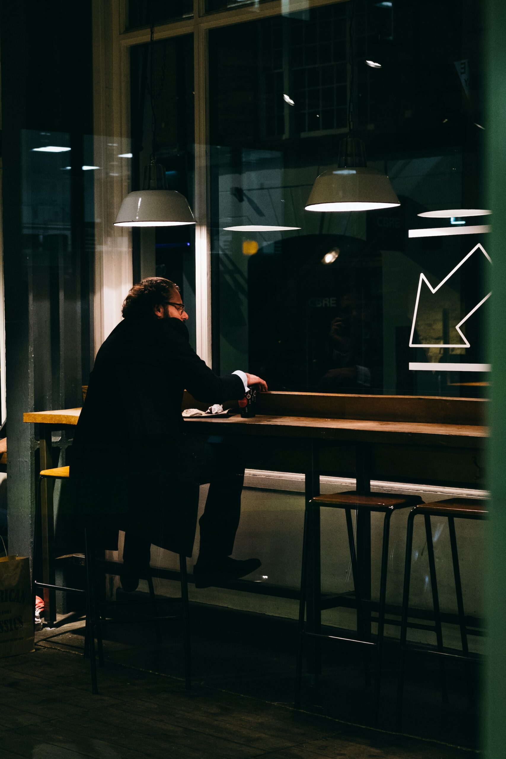 jay-clark-Man sitting in cafe late at night-unsplash