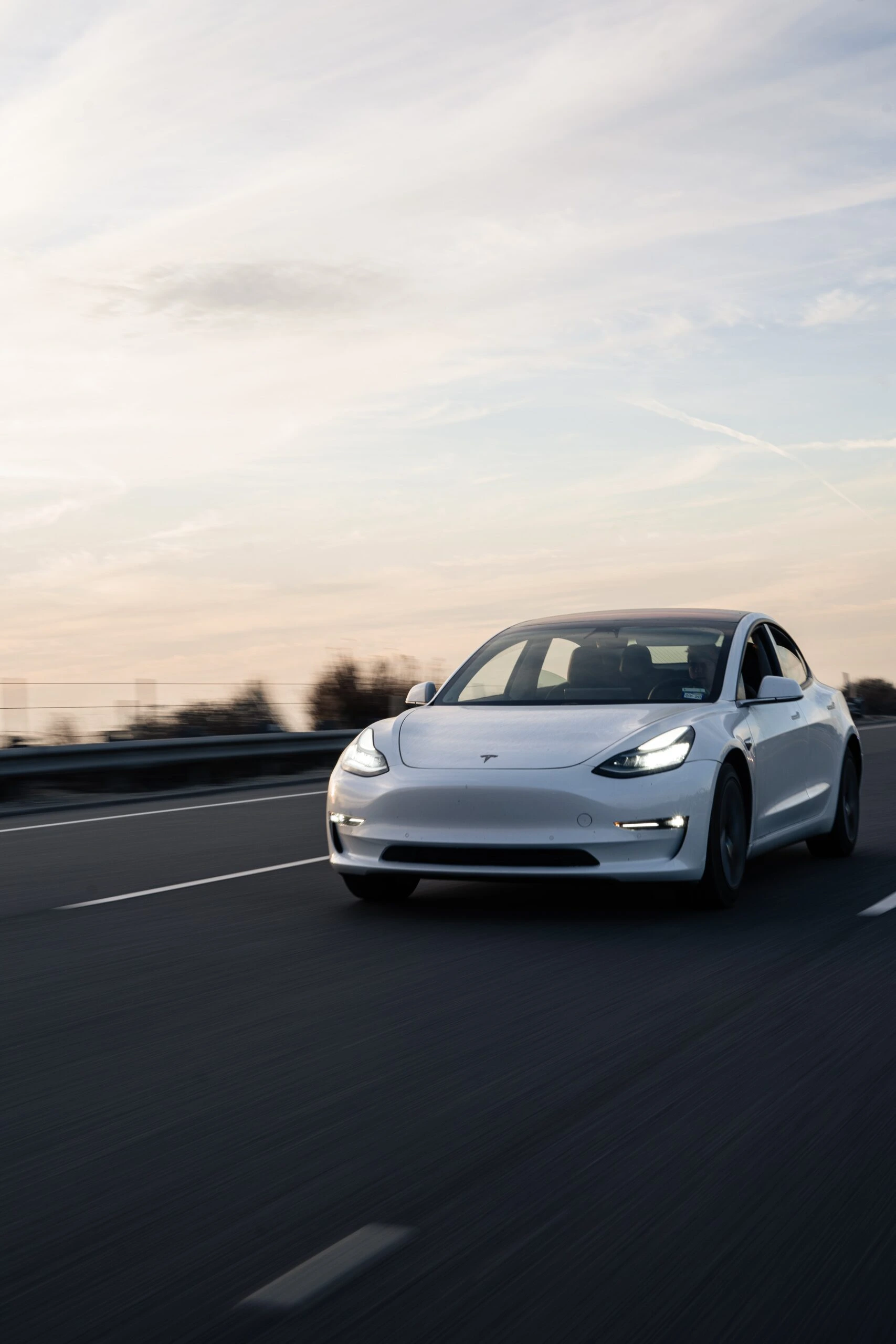 carter-baran-White Tesla Model 3 on highway-unsplash