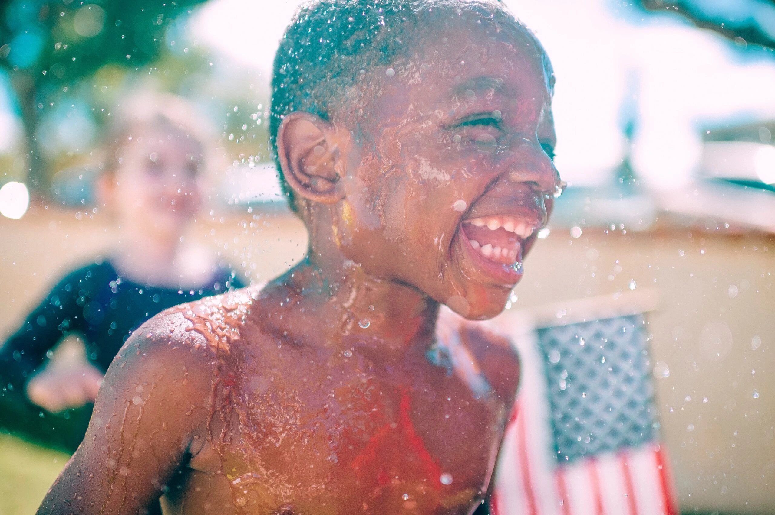 frank-mckenna-young man up close running in hydrant spray-unsplash