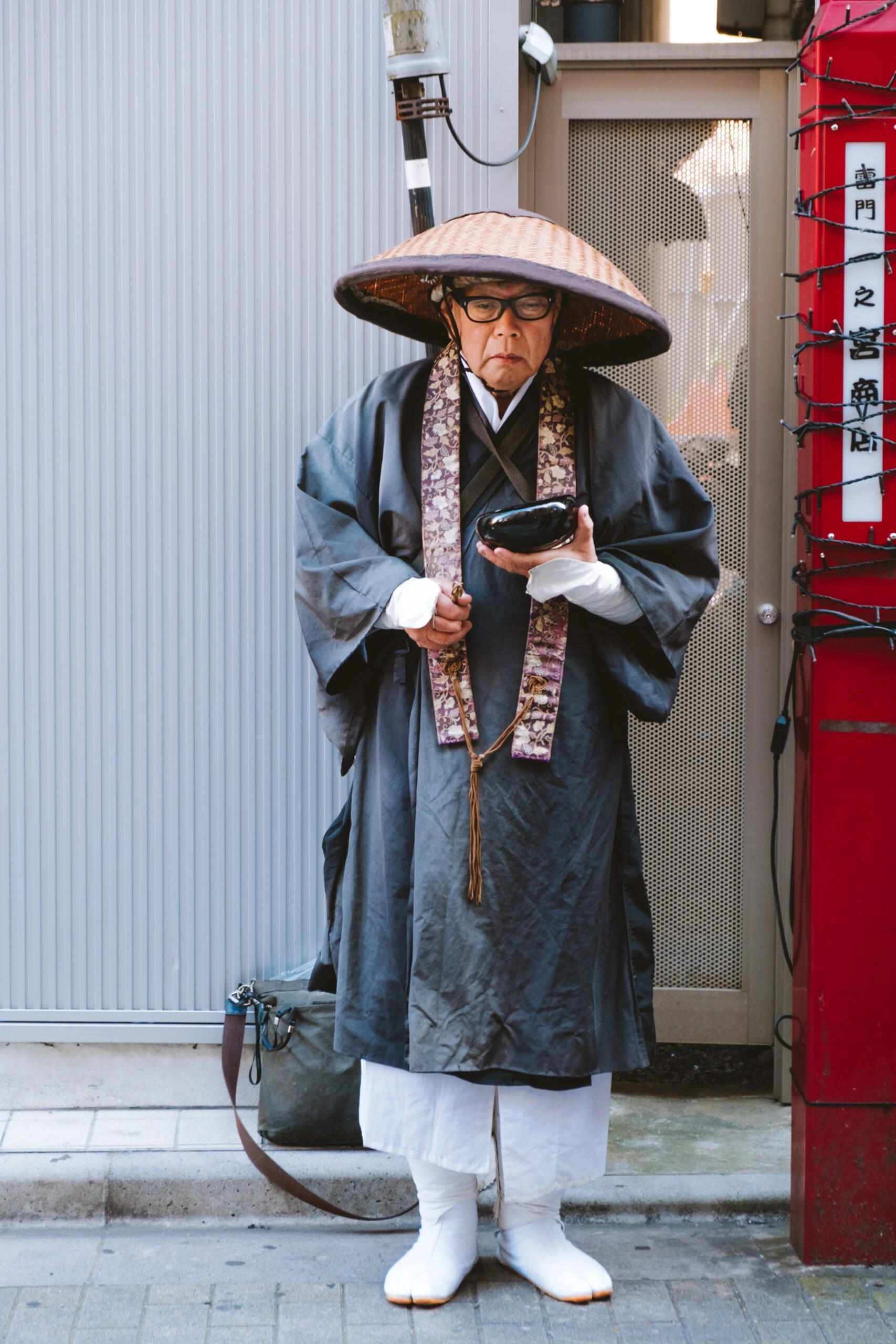 lucrezia-carnelos-Japanese Zen buddhist priest with bamboo hat holding black soapstone bowl-unsplash