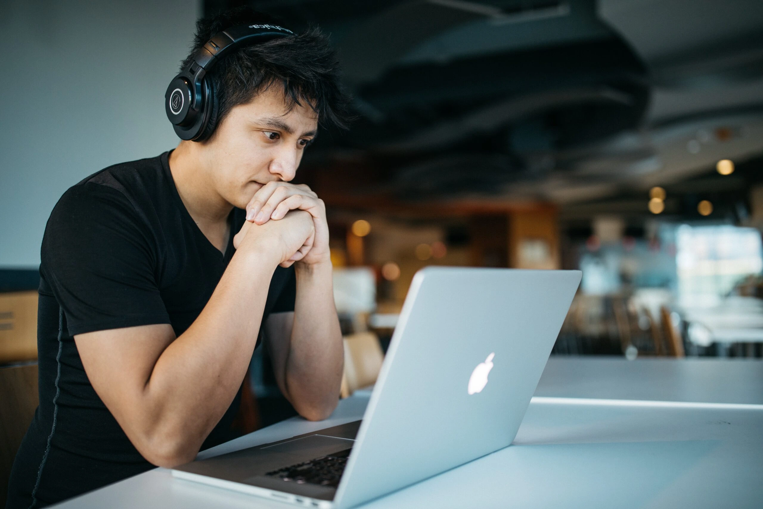 wes-hicks-Student-at-Macbook-in-library-with-headset-on-unsplash-scaled-1.webp